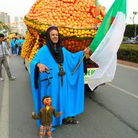 A puppeteer with a string puppet perform at a street parade, Coopérative Masrah Arous Wahran (<em>Or</em>an [Arabi<em>c</em>: <em>Wahrān</em>], Algeria). Photo: Houari Abdelkhalek