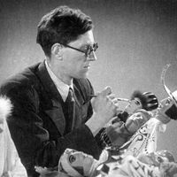 Boris Tuzlukov (1909-1974), Russian puppet theatre and stage designer, at work with puppets for Korol Olen (The <em>Ki</em>ng Stag, 1943) by Carlo Gozzi, production of Gosudarstvenny tsentralny teatr kukol (Sergei Obraztsov Central Puppet Theatre, Moscow, Russia). Photo courtesy of Collection: Gosudarstvenny akademichesky tsentralny teatr kukol imeni S.V. Obraztsova, Puppetry Museum (Moscow, Russia)