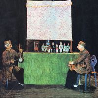 El <em>morshed</em> (“maestro”, el intérprete principal y narrador de la obra) toca el <em>tonbak</em> (tambor) y dirige el espectáculo de <em>kheimeh shab bazi</em>. Fotografía cortesía de Poupak Azimpour