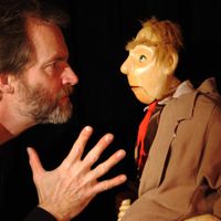 Rod Burnett and the Man in the Overcoat, in <em>The Half Chick</em> (1995) by Storybox Theatre (Bristol, UK), direction: Tanya Landman, design/construction: Rod Burnett, performer featured in the photo: Rod Burnett. Tabletop puppetry, height: 1.0 m. Photo: Rod Burnett